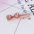 Golden hair clip with two orange heart gemstones and sparkling crystal accents - Champagne