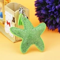 Close-up of green starfish keychain with rhinestones, leather tassel and bell charm - Silver Green