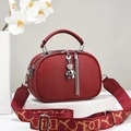 Dettaglio mini borsa tonda marrone rossiccio con motivo lychee e tracolla larga - Borgogna