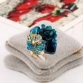 Golden open ring featuring blue crystal gemstone and green resin flower detail - Lake Blue