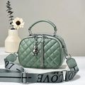 Détail du sac matelassé vert Morandi avec large bandoulière LOVE et breloque ours - Vert