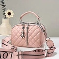 Détail macro d'un sac à main matelassé rose avec breloque ours et large bandoulière - Rose