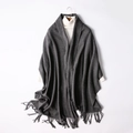 Dark grey wool blend scarf with fringe hanging on a hanger over a white sweater - Dark Gray
