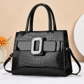 Detail of black glossy faux-crocodile leather handbag with large sparkling diamond buckle - Black