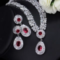 Vista macro del set di gioielli da sposa con pietre rosse su sfondo nero - Oro Bianco Zircone Rosso