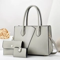 Detailed close-up of light gray pebbled leather tote, clutch and card holder set - Gray