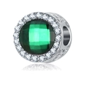 Dettaglio macro di un ciondolo in argento con pietra verde sfaccettata e halo lucente - Verde