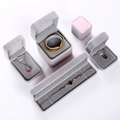 Macro shot of assorted dusty pink velvet jewelry boxes for necklaces and bracelets on white - Dusty Pink