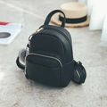 Detalle de mini mochila de cuero negro con herrajes dorados y pompón de piel suave - Con bola de pelo / Negro