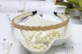 Detail of golden woven beaded headband placed on a white leaf tray with elegant pearls - Champagne (C7129)