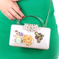Detail of white evening clutch featuring floral 3D decor and bee crown embellishments - Silver
