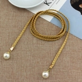 Fashionable golden braided waist chain with white pearl pendants on rustic background - Gold