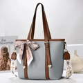 Detail of grey pebble leather bucket bag with brown handles and bohemian wide strap - Gray