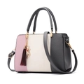 Close-up of pink and grey tricolor handbag with textured lychee grain and cat charm - Gray