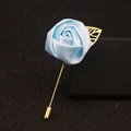 Blaue Satin-Rosenbrosche mit goldenen Metallblättern und langer Nadel auf schwarzem Grund - Hellblau