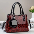 Detail of red and black leopard print handbag with glossy finish and matching coin purse - Red