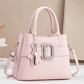 Detailed macro view of pink lychee grain leather texture and crystal buckle on handbag - Pink