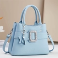 Detail of light blue crossbody bag featuring a sparkling crystal buckle and star charm - Blue