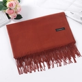 Red-brown cashmere scarf with fringe, folded neatly in a stylish minimalist display - Caramel color