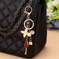 Golden cherry-style keychain with four-leaf clover and key charms on a black quilted bag - Single OPP Bag Packaging / Key Tassel Four Leaf Clover