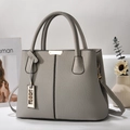 Detail of grey lychee pattern tote bag with gold metal trim and stylish shoulder strap - Dark Gray
