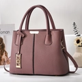 Detailed macro view of dust pink lychee leather texture and golden metal hardware on bag - Dusty Rose