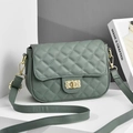 Detail of dark green quilted handbag featuring a golden metal turn-lock closure - Green