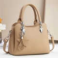 Close-up of beige leather bucket bag featuring lychee texture and star pendant charm - Khaki