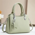 Detalle del bolso tipo cubo verde menta con textura de cuero granulado y adorno de estrella - Verde