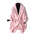 Pink knit wool shawl with fringe tassels displayed on a black turtleneck sweater - Pink