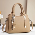 Close-up of beige lychee grain leather tote with silver hardware and star charm - Khaki