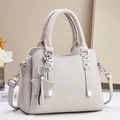Elegant beige pebbled leather tote bag with star charm and silver metal accents - Gray