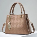 Detailed close-up of khaki quilted handbag with golden leaf charm and textured surface - Dark Khaki