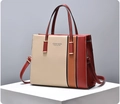 Detail der farblich abgesetzten Tragetasche in Beige, Karamell und Rot auf einem Podest - Rot