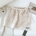 Détail du tricot ajouré blanc crème de la jupe avec cordon de serrage et étiquette latérale - crème