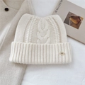 Detail of beige wool knit beanie with cat ears and ribbed cuff on a minimal background - 24*20cm / Cream