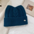 Detail of wool knit beanie with cat ears and small metal logo on a cozy winter backdrop - 24*20cm / Navy Blue