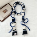 Dettaglio di sciarpa a maglia a righe blu navy con consistenza morbida ed etichetta - A Righe Blu Navy