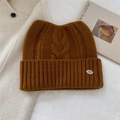 Détail d'un bonnet tricoté en laine à oreilles de chat avec texture torsadée épaisse - Orange