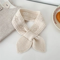 Dettaglio della sciarpa in maglia di lana con texture a treccia e design a incrocio - crema