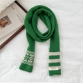 Dettaglio dell'etichetta 100% lana sulla sciarpa in maglia verde con strisce e fiocchi - Verde (Riga Fiocco di Neve)