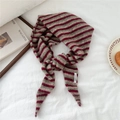 Close-up of fine knit triangle scarf with vintage burgundy and green stripes and brand tag - Coffee & Red Stripes