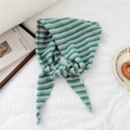 Detail shot of striped knitted scarf with green, lavender and grey patterns and woven label - Pink & Green Stripes
