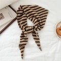 Detailed close-up of striped knit scarf featuring soft beige and brown textured wool fabric - Camel & Brown Stripes