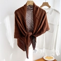 Close-up of caramel knit triangle shawl with hollow geometric diamond crochet patterns - Brown