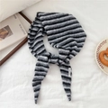 Close-up of soft striped knit triangle scarf with a premium woven brand label detail - Black & Grey Stripes