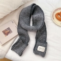 Detail eines grauen Strickschals mit gewebtem Logo-Etikett auf weißem Untergrund - 11*165cm / Grau Mit Taschen