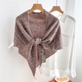 Close-up of a brown and white knitted wool shawl with a knot tied on a wooden hanger - Marled Pink (02Ocio)