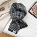 Detail of grey knitted scarf with white stripes and brand label on fabric background - Dotted Dark Gray