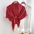 Detailed macro view of the thick red chunky knit wool scarf with flecked texture and label - Marled Red (04Ocio)